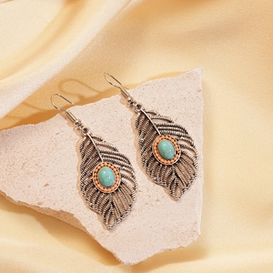 Detail of vintage silver leaf earrings with turquoise and orange beads on silk