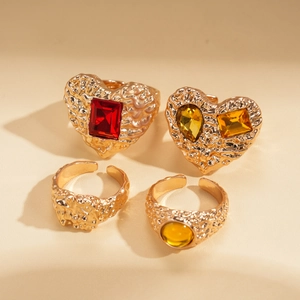 Detailed view of 4-piece vintage gold heart rings with colorful gems and lava texture