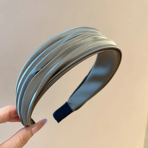 Détail du serre-tête plissé en satin gris-vert montrant la texture et les embouts antidérapants