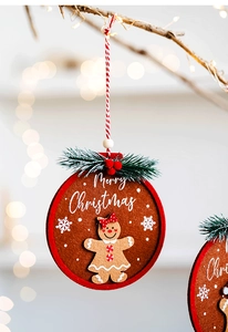Close-up of felt gingerbread man Christmas ornament hanging on a festive tree branch