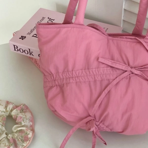 Detailed close-up of a pink pleated tote bag featuring a cute bow and soft fabric texture