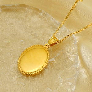 Golden oval pendant necklace with twisted rope edge on golden silk background