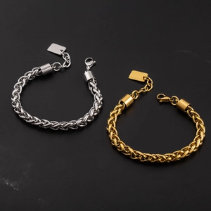 Gold and silver chunky braided basket chain bracelets with metal tags on black stone