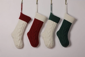 Detail of four knit Christmas stockings with cable patterns in white, red, and green colors