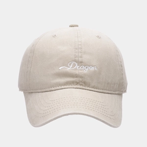 Detail of white cursive Dragon embroidery on beige cotton twill baseball cap visor