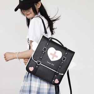 Detail of sweet girl heart backpack with side wings and cross emblem in black and white