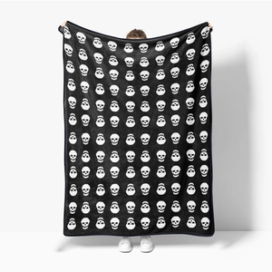 Macro shot of soft black flannel blanket featuring white skull patterns and bound edges