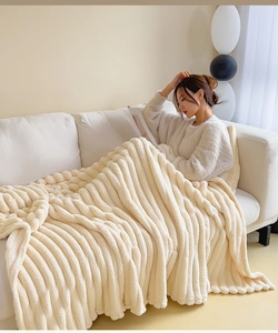 Close-up of cream faux rabbit fur blanket with striped texture for home comfort