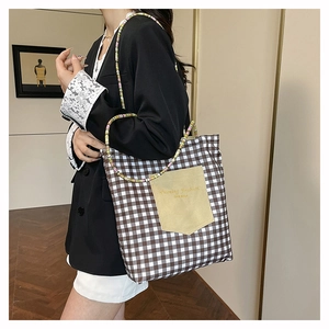 Bolso tote de lona a cuadros con bolsillo amarillo y correa de cuentas en modelo