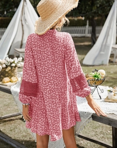 Close-up of floral red summer dress featuring delicate white lace trim on the sleeve and hem