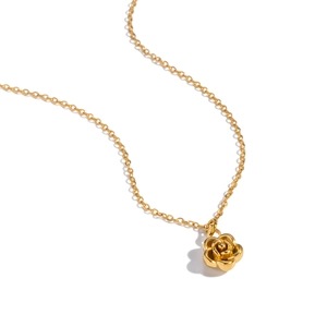 Close-up of a delicate golden camellia rose pendant necklace with fine chain detail