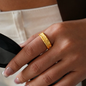 Detail of 24k gold-plated ring with liquid metal wave design and frosted texture