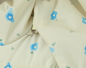 Detailed close-up of floral puffer jacket featuring a hidden silver metal zipper and seams