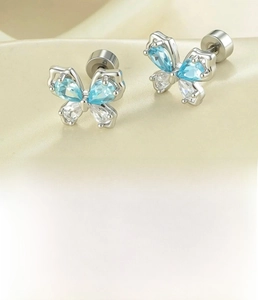 Detailed view of butterfly cartilage stud earrings with light blue zircon and steel backing