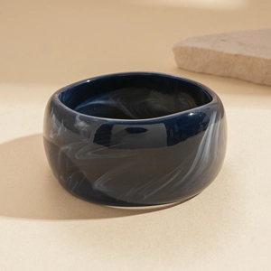 Macro detail of deep blue marble acrylic bracelet showing smooth texture and smoky patterns