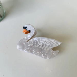 Elegant swan-shaped acetate hair claw clip with pearlescent white finish and orange beak
