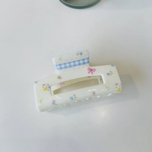 Detail of floral rectangular hair claw with blue plaid ribbon and white lace trim