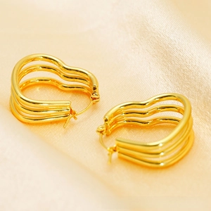 Macro di orecchini a cuore in oro 18k con design a triplo strato ondulato su seta champagne