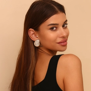 Silver conch shell stud earrings with spiral texture shown on model for sizing