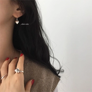 Minimalist 925 sterling silver heart earrings and knot ring shown on a model