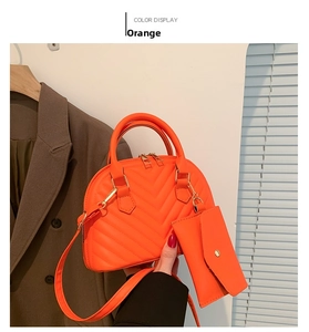 Detail der orangefarbenen gesteppten Muscheltasche und passendem Etui mit V-Nähten