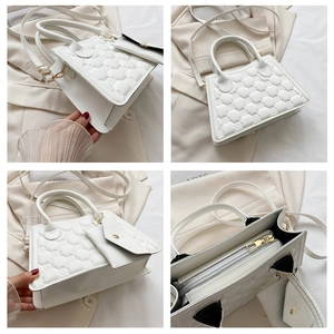 Detailed views of white quilted trapezoid handbag with dual handles and crossbody strap