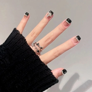 Detail of silver branch rings with black gemstone and Saturn nail art decoration