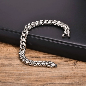 Detailed close-up of polished silver Cuban link bracelet with secure fold-over clasp