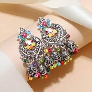 Detail of bohemian heart earrings with colorful beads and small jingling bell tassels