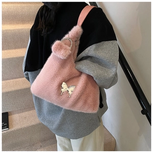 Detail of pink faux fur shoulder bag with silver butterfly and plush charm detail