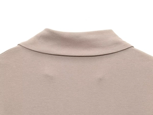 Primer plano del tejido de punto piqué y detalles del cuello en el vestido beige