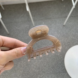 Close-up of a brown translucent square hair claw clip with multi-tooth design for styling