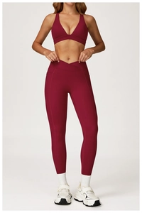 Detail of high-waist yoga leggings with crossover waistband and side pockets in burgundy