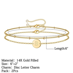 Détail d'un ensemble de bracelets en or 14 carats avec un pendentif disque lettre B gravé