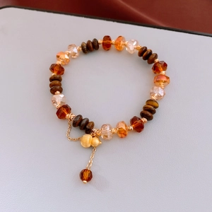 Détail de perles œil-de-tigre et pendentif gourde dorée au style chinois rétro