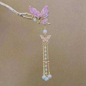 Close-up of pink enamel butterfly hair pin with cascading pearl tassels and gold plating