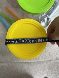 Close-up measuring 12cm diameter of yellow sealing lid for Ninja Creami NC501 series