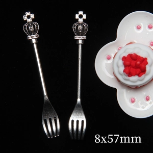 Macro detail of miniature silver alloy crown forks for dollhouses, size 8x57mm