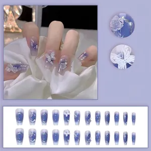 Detail of purple gradient press-on nails with 3D butterflies, pearls, and embossed flowers