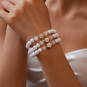 Three-piece acrylic beaded bracelet set with enamel flower charms and soft pink tones