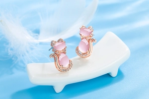 Detail view of rose gold cat earrings with pink hibiscus stone and clear zircons