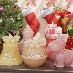 Close-up of Christmas scented candles with reindeer and snowman embossed textures