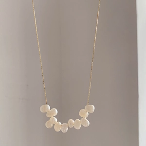 Macro shot of natural baroque freshwater pearls arranged on a fine gold necklace chain