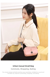 Pink shell crossbody bag with metal cat charm and printed wide shoulder strap detail