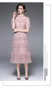 Détail de la robe à volants en tulle rose avec broderie florale et manches bouffantes