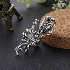 Macro shot of silver dragon ring with detailed carvings on a vintage background