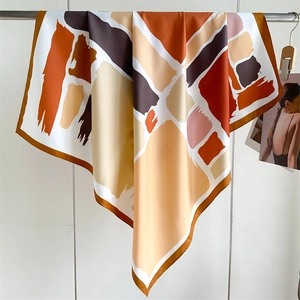 Detailed texture of 90x90cm luxury twill silk scarf with orange and brown geometric print