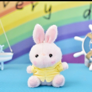 Detailed close-up view of a cute pink plush rabbit toy wearing a yellow hoodie