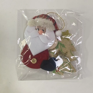 Dettaglio del puntale di Babbo Natale in peluche confezionato con Merry Christmas