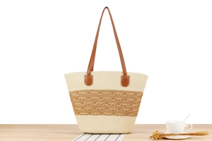 Close-up of hand-woven striped tote bag with leather straps on wooden table
